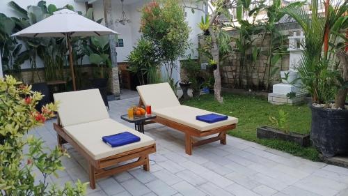 two chairs and an umbrella on a patio at VILLA PAPA PUTU in Banjar