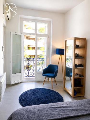a bedroom with a blue chair and a window at Cannes - Modern balcony flat perfect location in Cannes