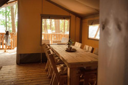 a wooden dining table in a room with a deck at Jocomo Parc in Lanaken