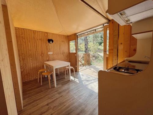 a small kitchen with a table and chairs in a house at Camping 4 étoiles - Piscine - ccbgbac in Arques