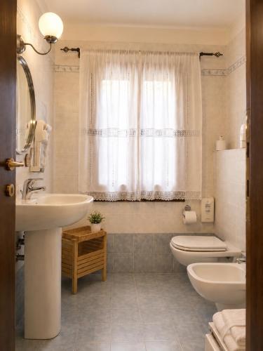a bathroom with a sink and a toilet and a window at La Busa alloggi e trattoria in Ponte San Nicolo