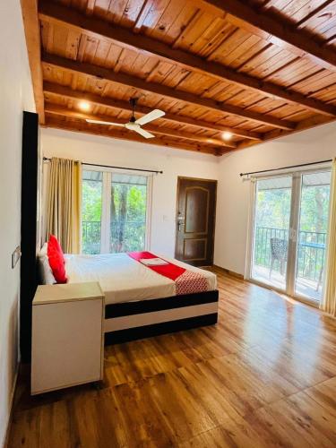 a bedroom with a bed in a room with wooden floors at Oxygen Rain Forest Resort in Kūmudi
