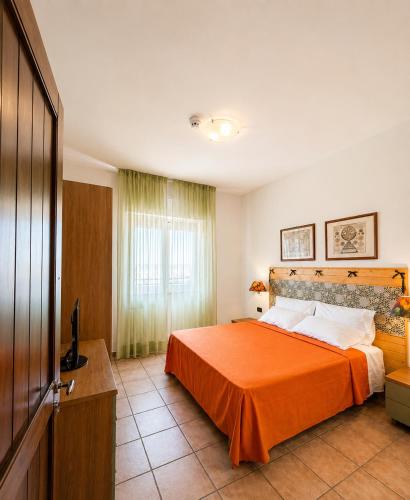 a bedroom with a bed with an orange blanket at Riva Sweet Home in Giovinazzo