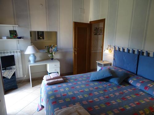 a bedroom with a bed with a blue comforter at La Casa Del Sole in Bomarzo