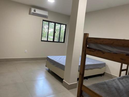 a bedroom with two bunk beds and a window at Sítio em Guarapari in Guarapari