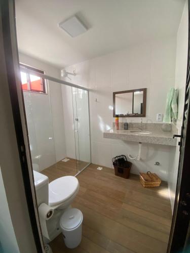 a bathroom with a toilet and a sink and a mirror at Sítio em Guarapari in Guarapari
