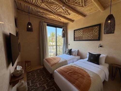 two beds in a room with a window at Palm Surf & Spa Hotel in Agadir