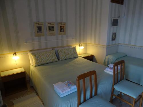 a bedroom with a bed with two chairs and two lamps at La Casa Del Sole in Bomarzo