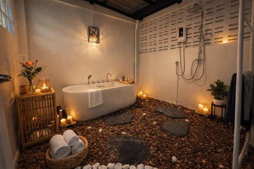 a bathroom with a tub and a shower with candles at Cozy house at Central Hatyai in Sathani Khlong Rian