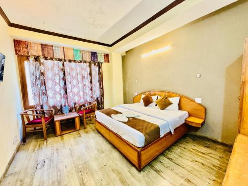 a bedroom with a large bed and a window at Hotel Rana Taradevi in Shimla