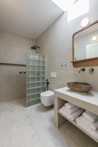 a bathroom with a sink and a toilet and a mirror at PEA Plaka Authentic Home in Plaka Milou
