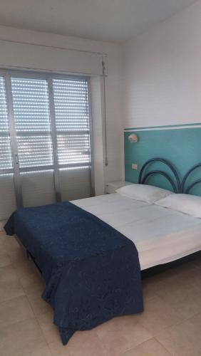a bedroom with a large bed with a blue headboard at Residence Danubio in San Benedetto del Tronto