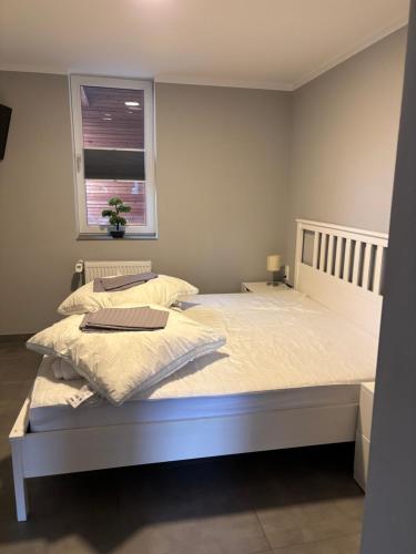 a bedroom with a white bed and a window at Fachwerk FeWo Schoningen in Uslar