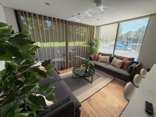 a living room with a couch and a table at Escape to Willow Wharf - A Luxury Thames Houseboat in Chertsey
