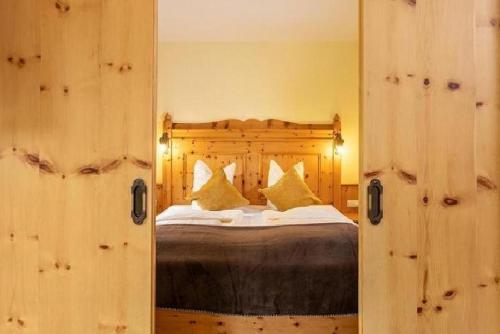 a bedroom with a bed and a mirror at Naturhotel Hüttenwirt im Grossarltal in Hüttschlag