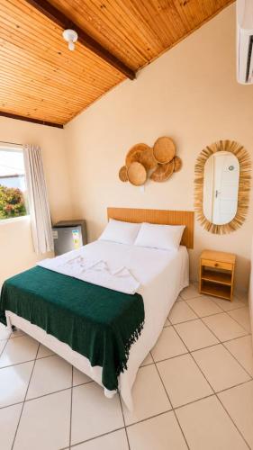 a bedroom with a large bed and a mirror at Pousada Terra Nostra in Prado