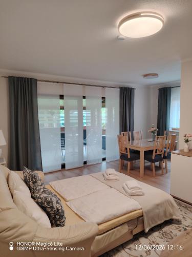 a bedroom with a large bed and a table at Ferienwohnung Am Wald in Bad Marienberg
