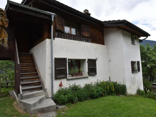 een wit huis met een trap en een raam bij detached holiday home in Grengiols Valais views in Grengiols