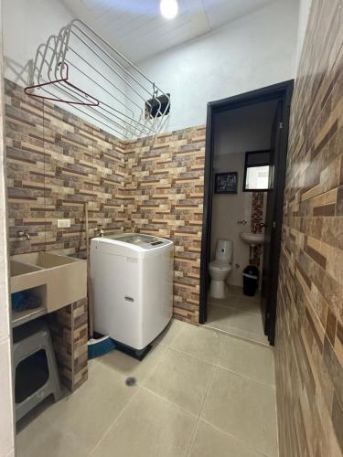 a bathroom with a sink and a brick wall at SANTYS HOUSE MELGAR apartamento amoblado 6 Huéspedes in Melgar