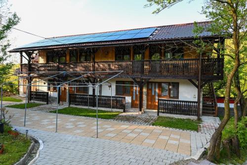 a house with a balcony with solar panels on it at Muntele cu dor in Crevileşti