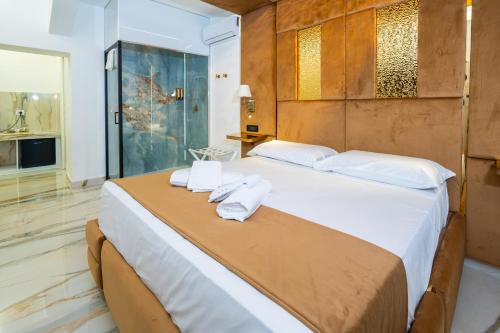 a bedroom with a large bed with towels on it at Letoh Apartment in Catania