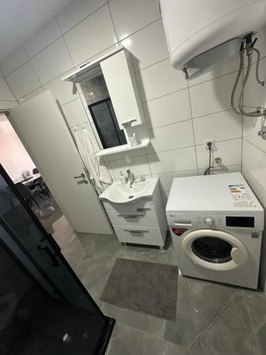 a bathroom with a washing machine and a sink at Apartment Balkan in Modriča