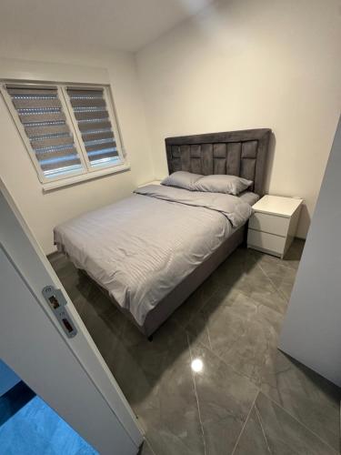 a small bedroom with a bed and a window at Apartment Balkan in Modriča