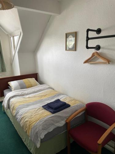 a bedroom with a bed and a red chair at Victoria Inn in Alston