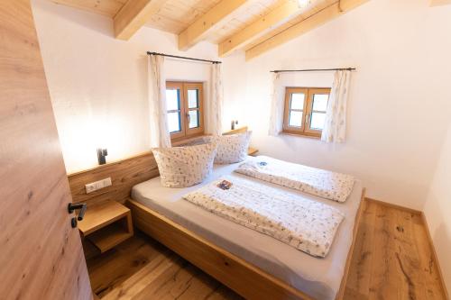 two beds in a room with two windows at Chalet Kogelleiten in Ramsau