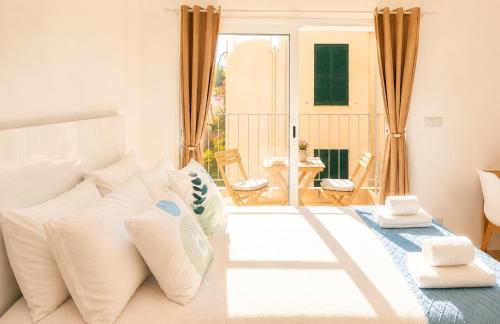 a bedroom with a white bed with pillows at Social Lodge Happiness Studios in Funchal
