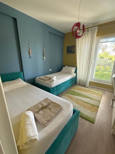 a bedroom with two beds and a window at Lalzi Vacation Apartment in Lalzit Bay
