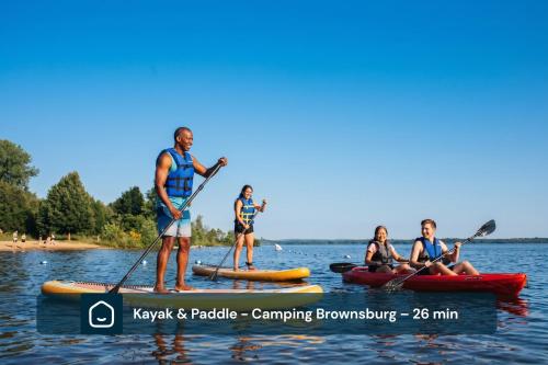 a group of people on kayaks on the water at Chalet Luméo Private SPA, Golf & carling Lake in Brownsburg
