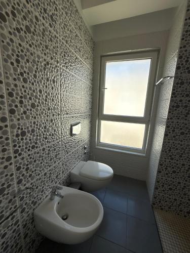 a bathroom with a sink and a toilet and a window at Lalzi Vacation Apartment in Lalzit Bay