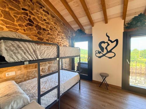a room with two bunk beds and a stone wall at YourHouse A Casa Do Cordeiro in Allariz