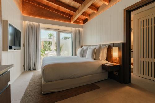 a bedroom with a large bed and a television at Epi Baie de Pampelonne in Saint-Tropez