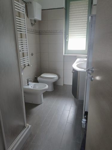 a bathroom with a toilet and a sink at VERDEDERA Casa Vacanze in Portocannone