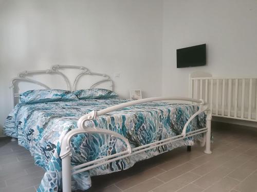a bedroom with a bed with a white frame and a tv at VERDEDERA Casa Vacanze in Portocannone