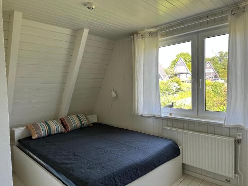 ein kleines Zimmer mit einem Bett und einem Fenster in der Unterkunft Schleirauschen in Klein Brodersby