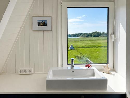 ein Badezimmer mit Waschbecken und großem Fenster in der Unterkunft Schleirauschen in Klein Brodersby
