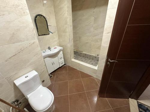 a bathroom with a toilet and a sink and a mirror at Marina Valley مارينا فالي in El Alamein