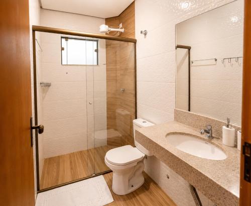 a bathroom with a toilet and a sink and a shower at Pousada Voo das Garças in Bonito