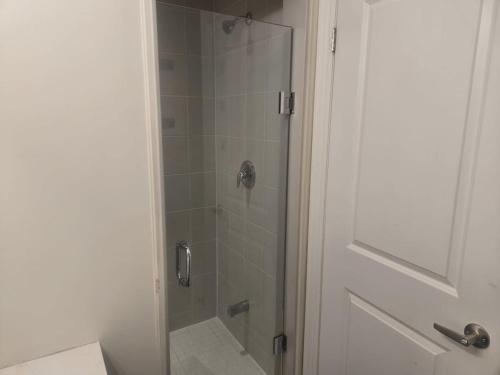 a bathroom with a shower with a glass door at Short stay and exploring the city in Markham