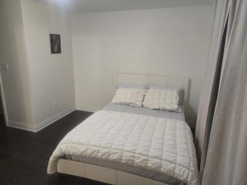 a bed with two pillows on it in a bedroom at Short stay and exploring the city in Markham