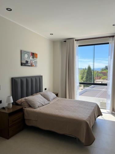 a bedroom with a large bed and a large window at Monoambiente Amplio in Tarija