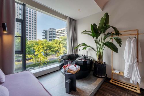 a bathroom with a large tub and a large window at M Hotel in Hangzhou