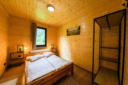 a bedroom with a bed in a wooden room at Czirják Kulcsosház in Bucsin