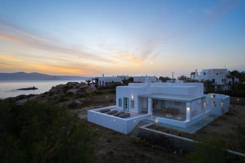 a white house with a sunset in the background at Acron Vigla in Mikri Vigla