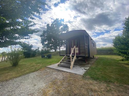 a tiny house sitting on top of a field at La Roulotte au Paradis in Arc-et-Senans