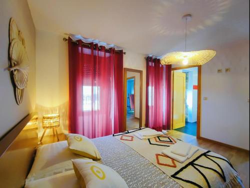 a bedroom with a large bed with red curtains at Casa dos Côtos. in Castro Laboreiro