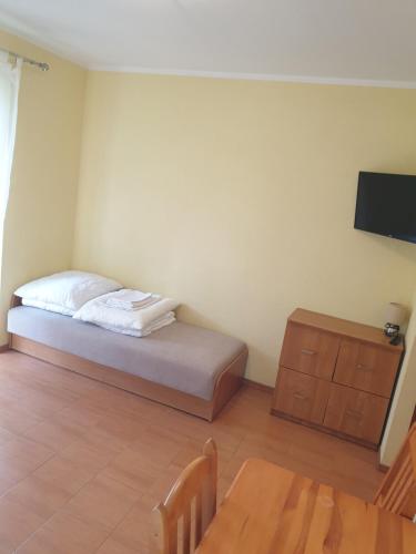 a bedroom with a bed and a wooden table at Zagajnik in Dębki